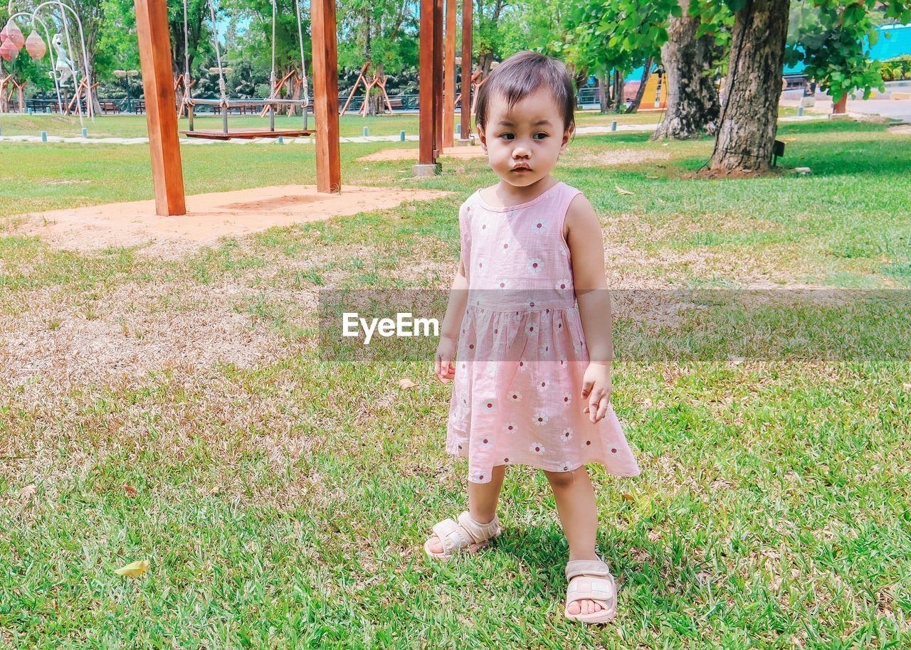 Cute little asian thai girl standing in the park.