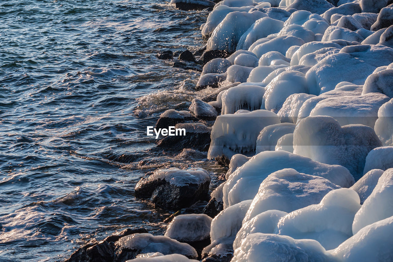 Frozen rocks in sea during winter