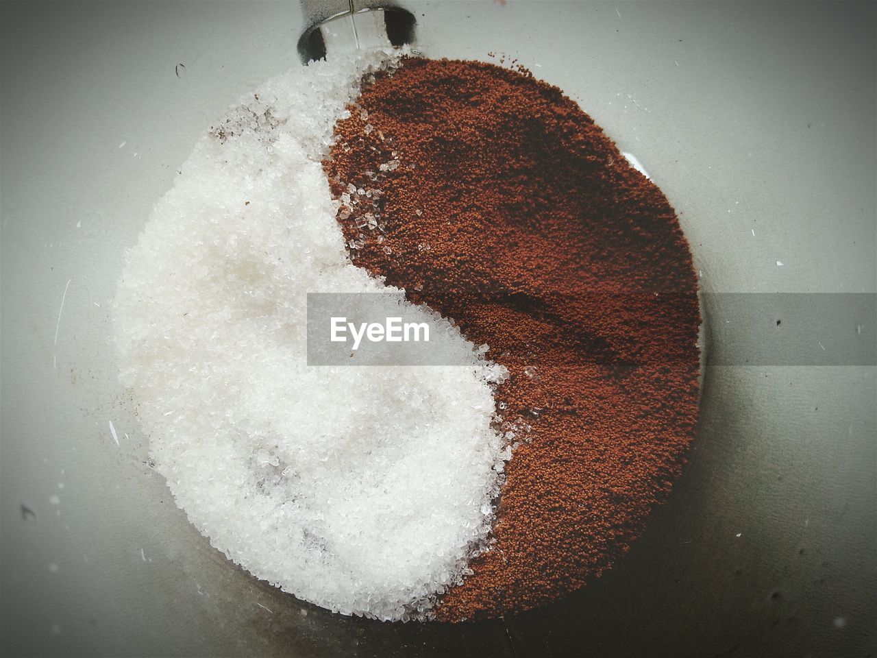 Directly above view of sugar and ground coffee arranged as yin yang symbol