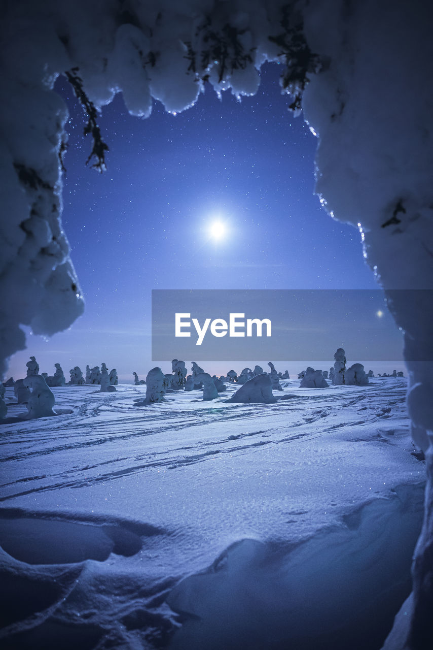 Scenic view of snow covered landscape against sky at night