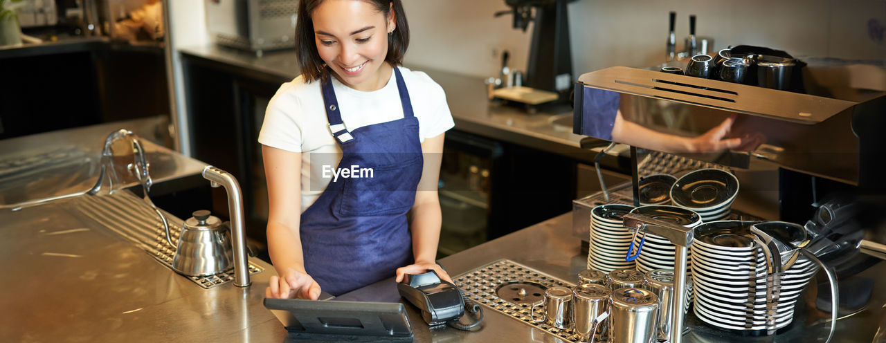 side view of young woman using mobile phone while sitting on table