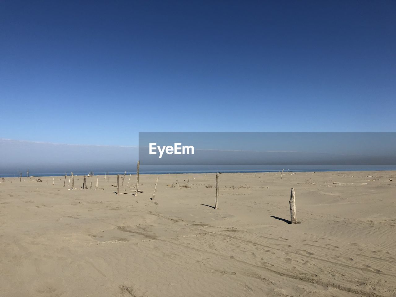 Scenic view of beach against clear blue sky