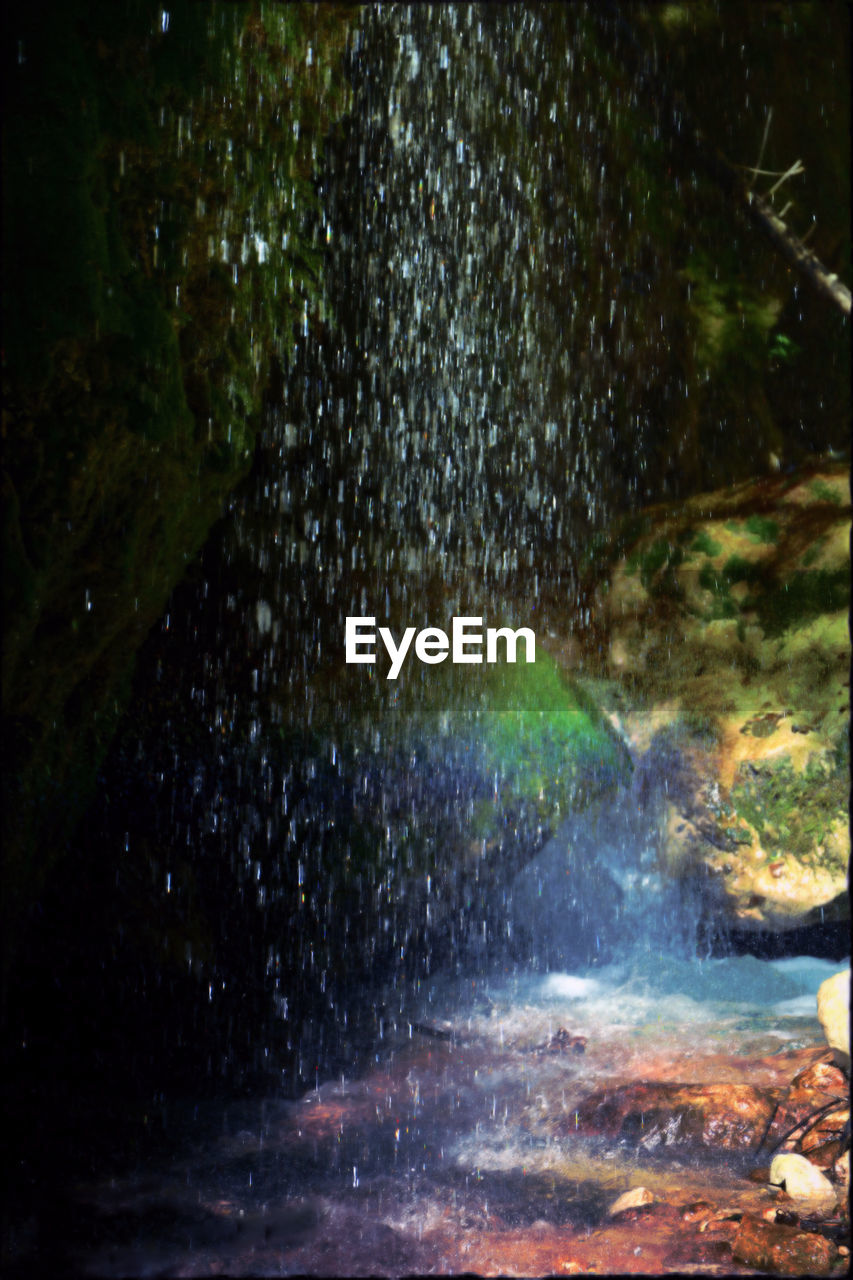 WATER FLOWING THROUGH ROCKS IN FOREST