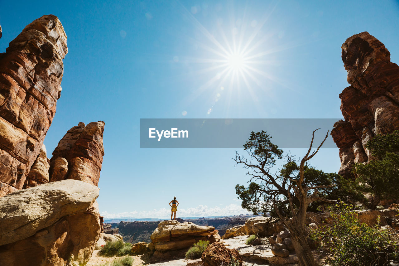 Woman hiker with hands on hips looks at the view in the maze utah