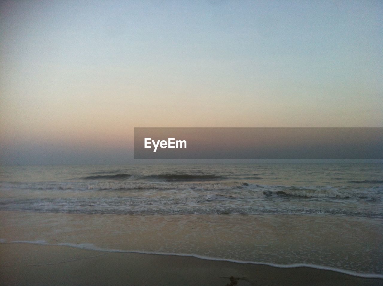 SCENIC VIEW OF BEACH AGAINST SKY AT SUNSET