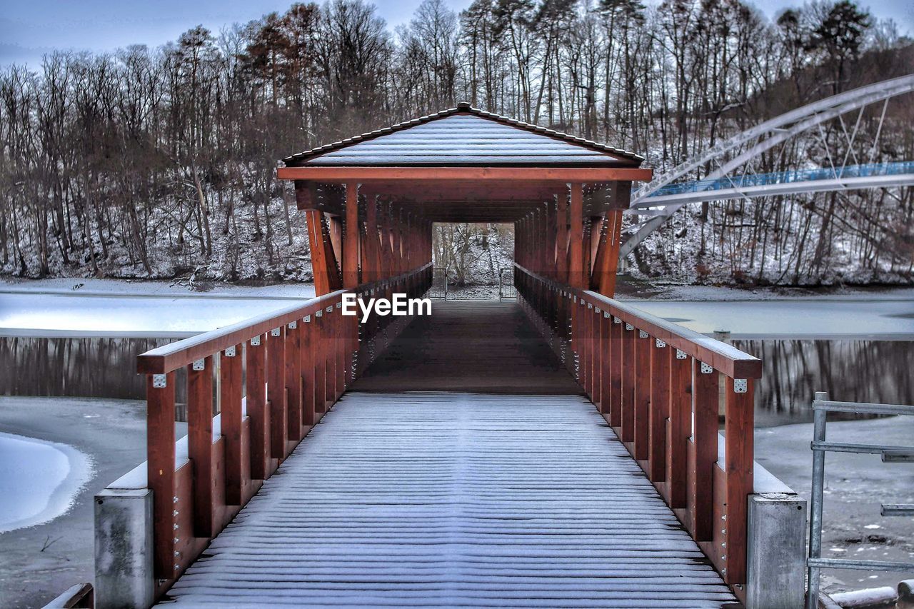 WOODEN FOOTBRIDGE IN SNOW COVERED LAND