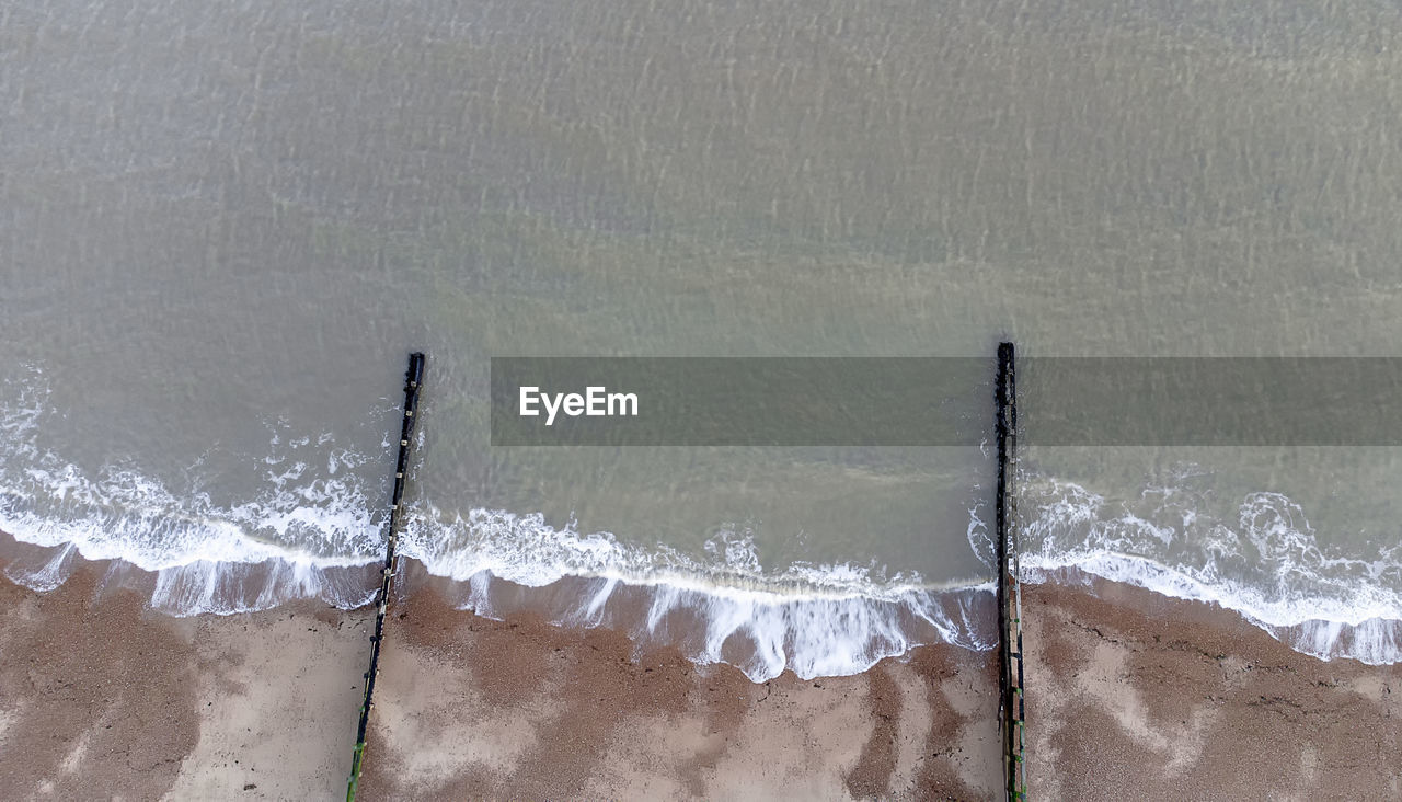 Looking down on waves breaking on a shingle beach in suffolk, uk