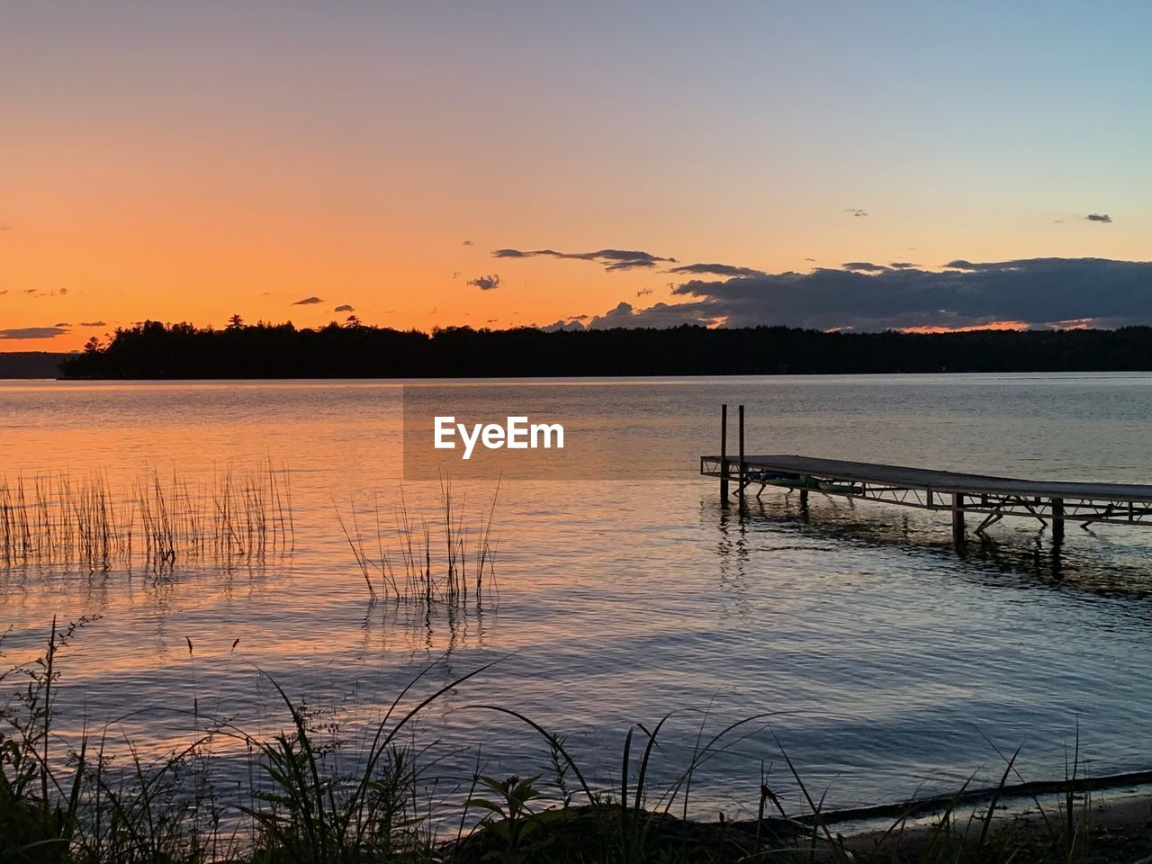 SCENIC VIEW OF LAKE AGAINST ORANGE SKY DURING SUNSET