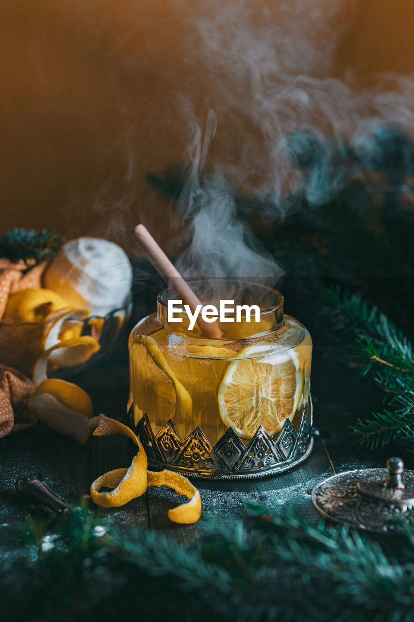 Autumn or winter hot tea with lemon and sugar with steam above the cup on a dark background