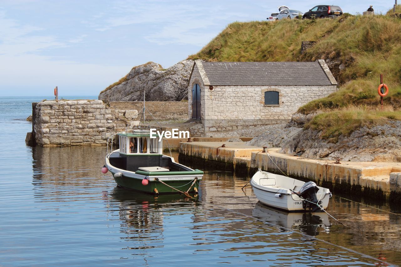 BOAT MOORED ON SEA AGAINST BUILDINGS