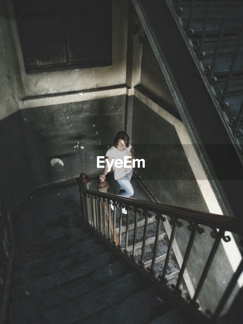 High angle view of woman standing at staircase in building
