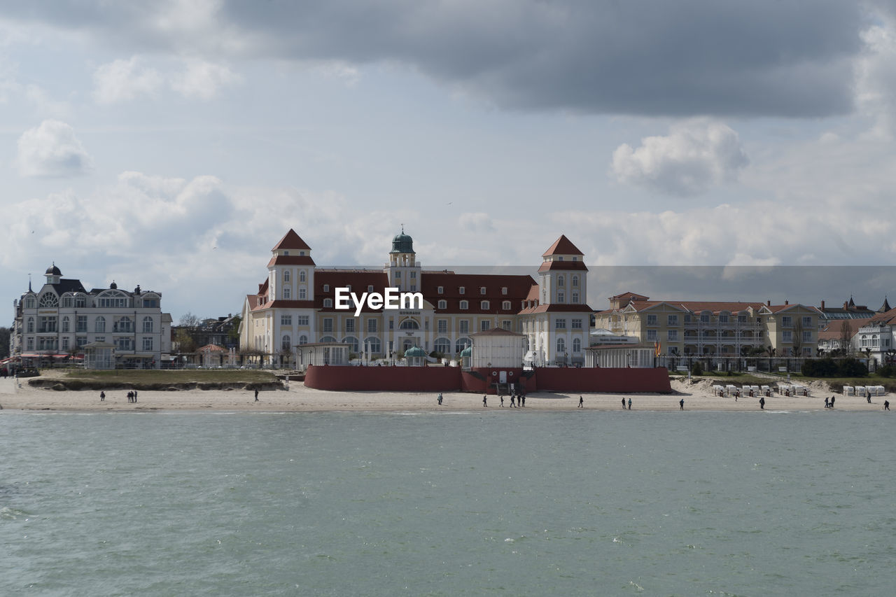 Buildings by sea against sky in city