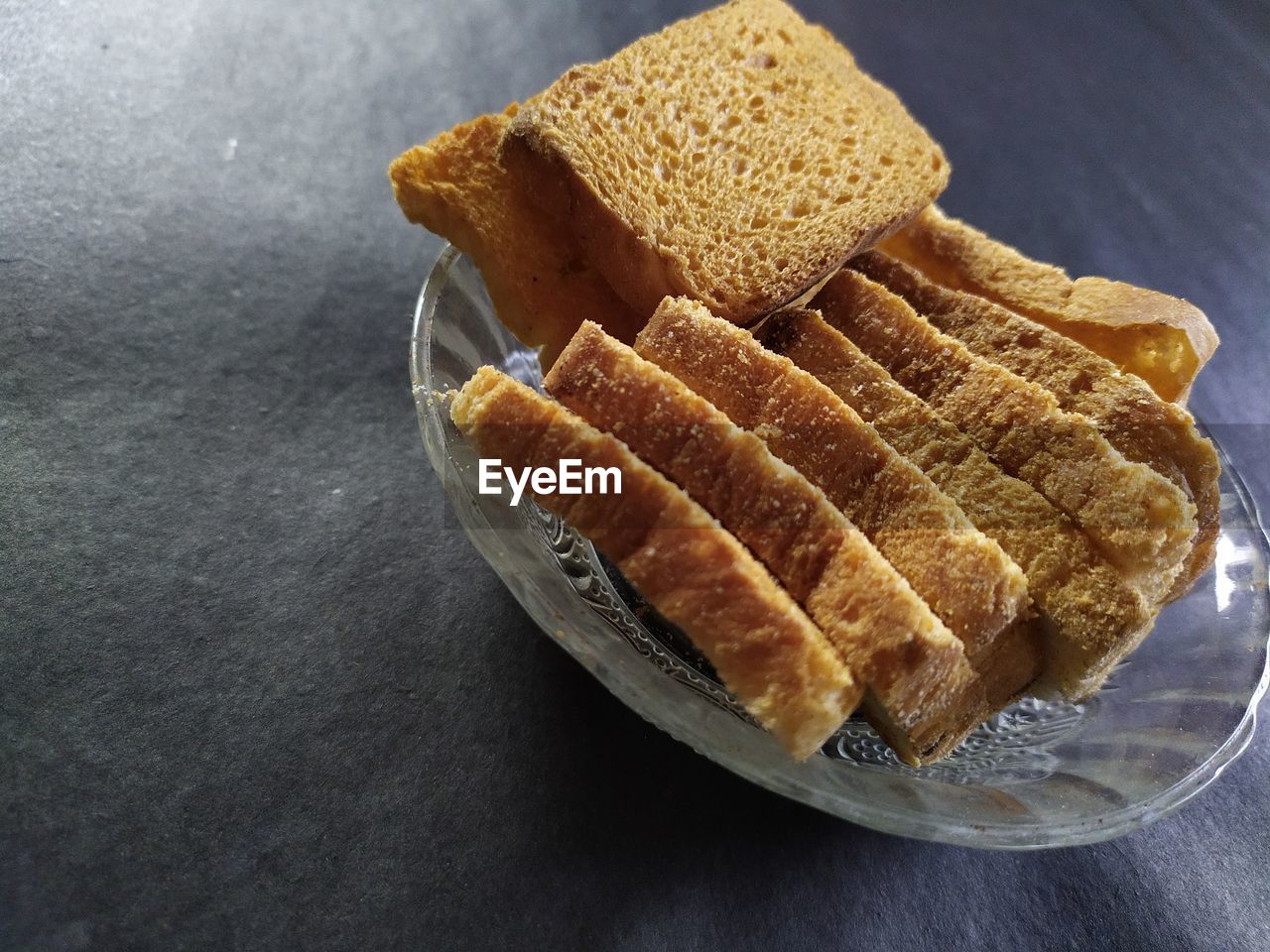  view of bread biscuits in a glass bowl, black background.