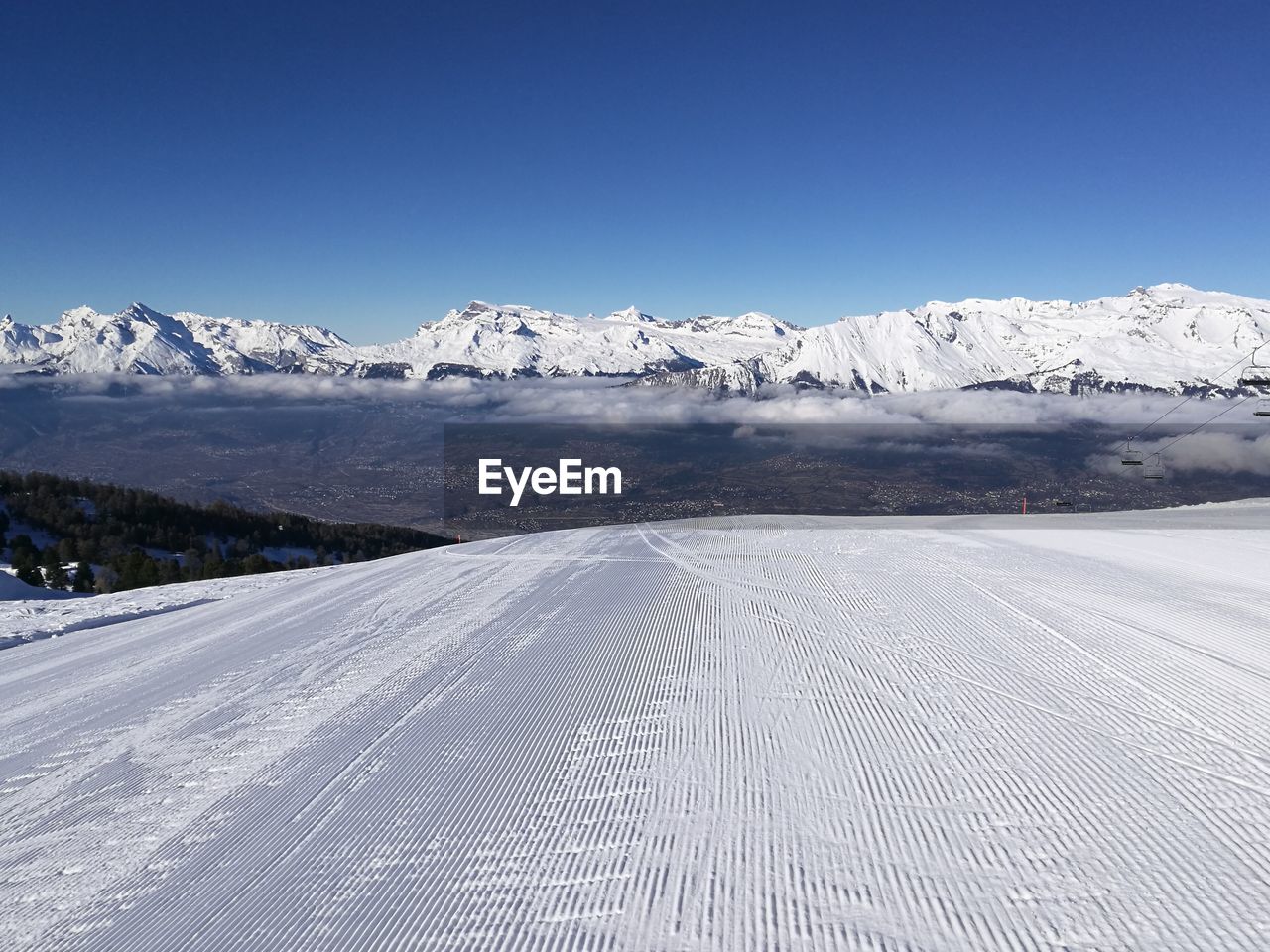 Scenic view of snowcapped mountains against clear blue sky