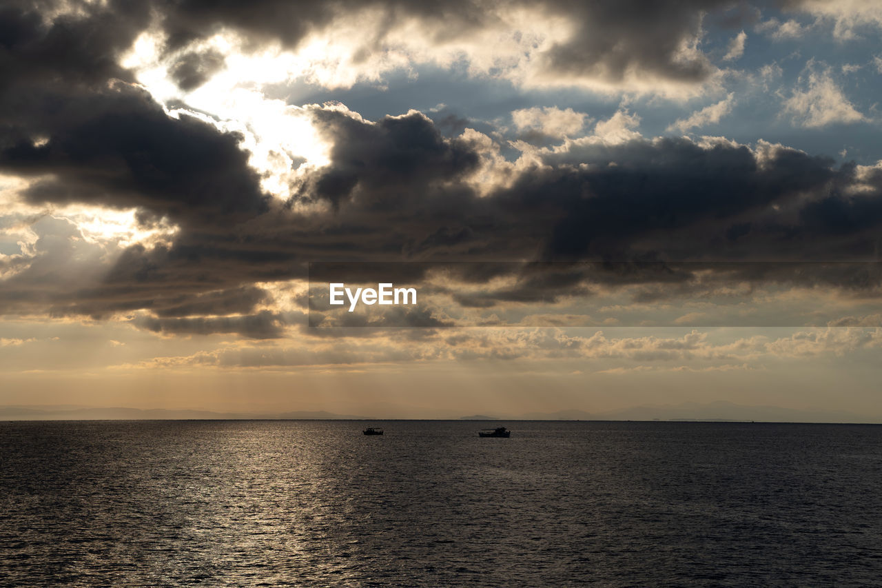 sky, cloud, water, sea, horizon, beauty in nature, sunset, scenics - nature, horizon over water, nature, dramatic sky, sunlight, tranquility, environment, cloudscape, seascape, ocean, tranquil scene, dusk, no people, sun, outdoors, evening, shore, idyllic, storm, travel, coast, sunbeam, nautical vessel, moody sky, reflection, travel destinations, urban skyline, awe, land, landscape, afterglow, transportation, beach, wave
