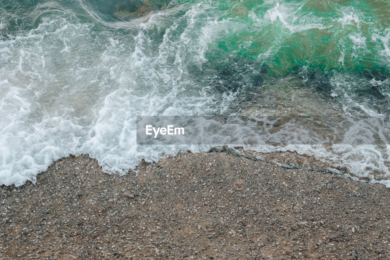 HIGH ANGLE VIEW OF WAVES ON SHORE