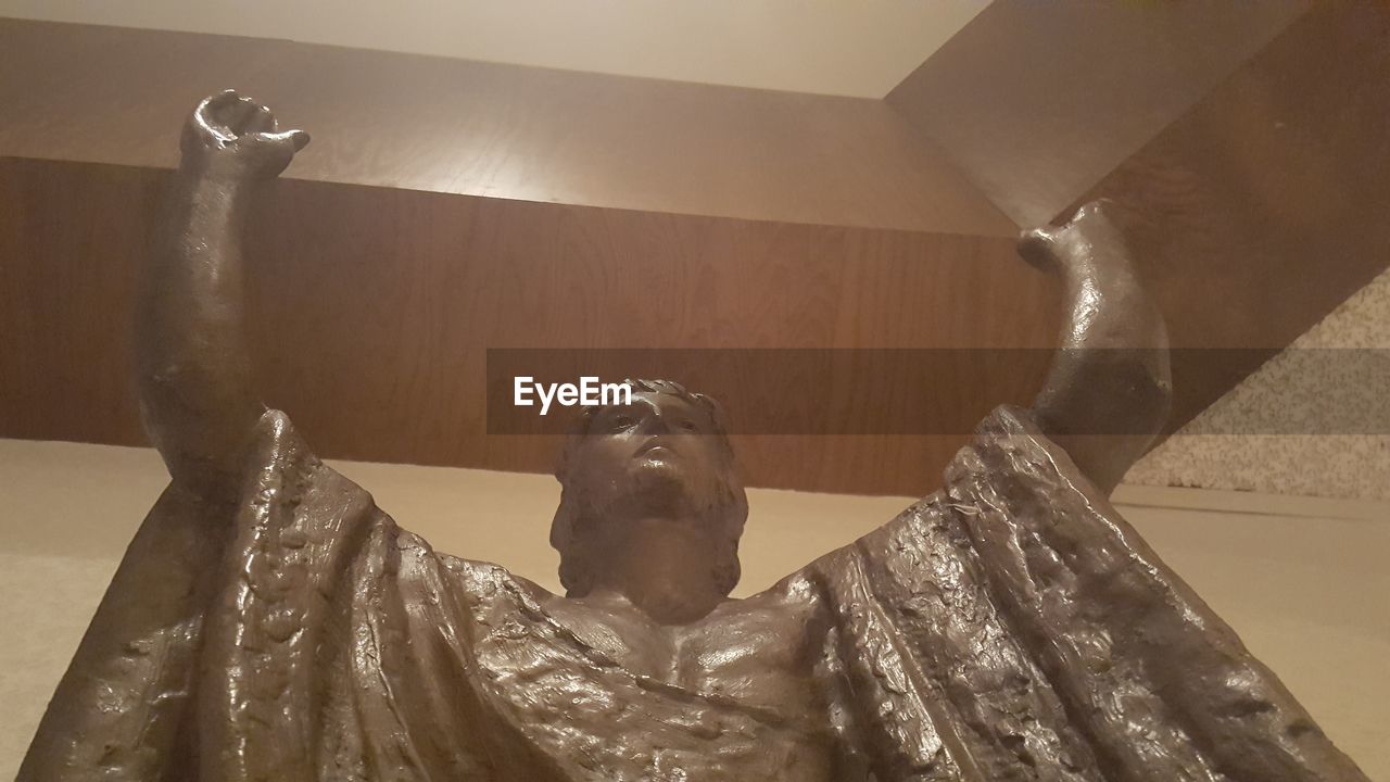 LOW ANGLE VIEW OF MAN SITTING IN BATHROOM