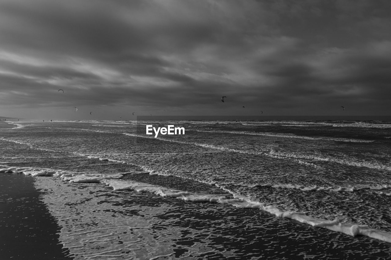 sky, black and white, sea, cloud, water, horizon, land, monochrome, monochrome photography, coast, nature, wave, beach, scenics - nature, ocean, environment, beauty in nature, landscape, tranquility, no people, tranquil scene, outdoors, shore, dramatic sky, storm, travel destinations, day, sand, travel, horizon over water, darkness, overcast, non-urban scene, motion, black, wind wave, animal, seascape