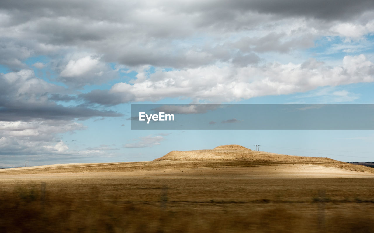 View of desert against cloudy sky