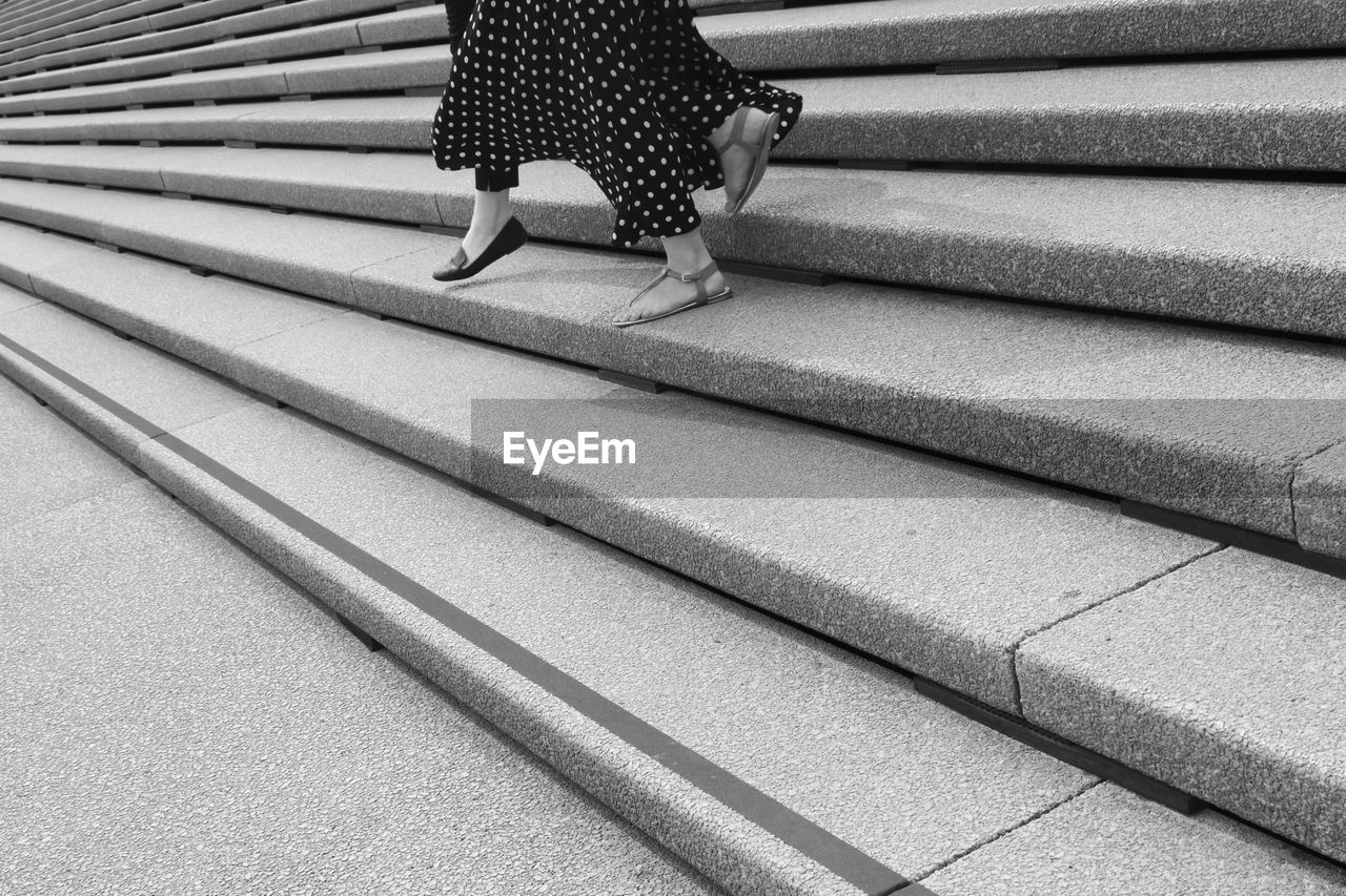 LOW SECTION OF WOMAN WALKING ON FLOOR