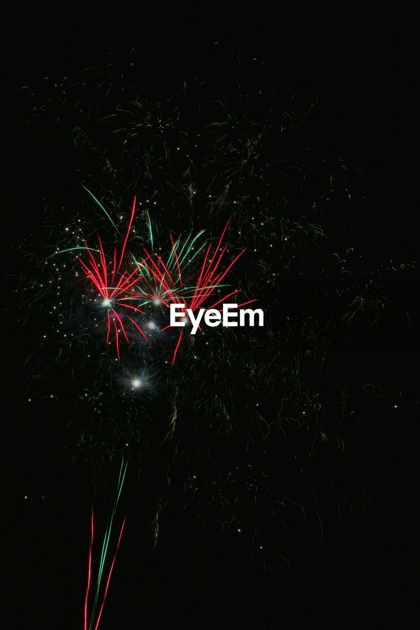 Low angle view of fireworks against sky at night