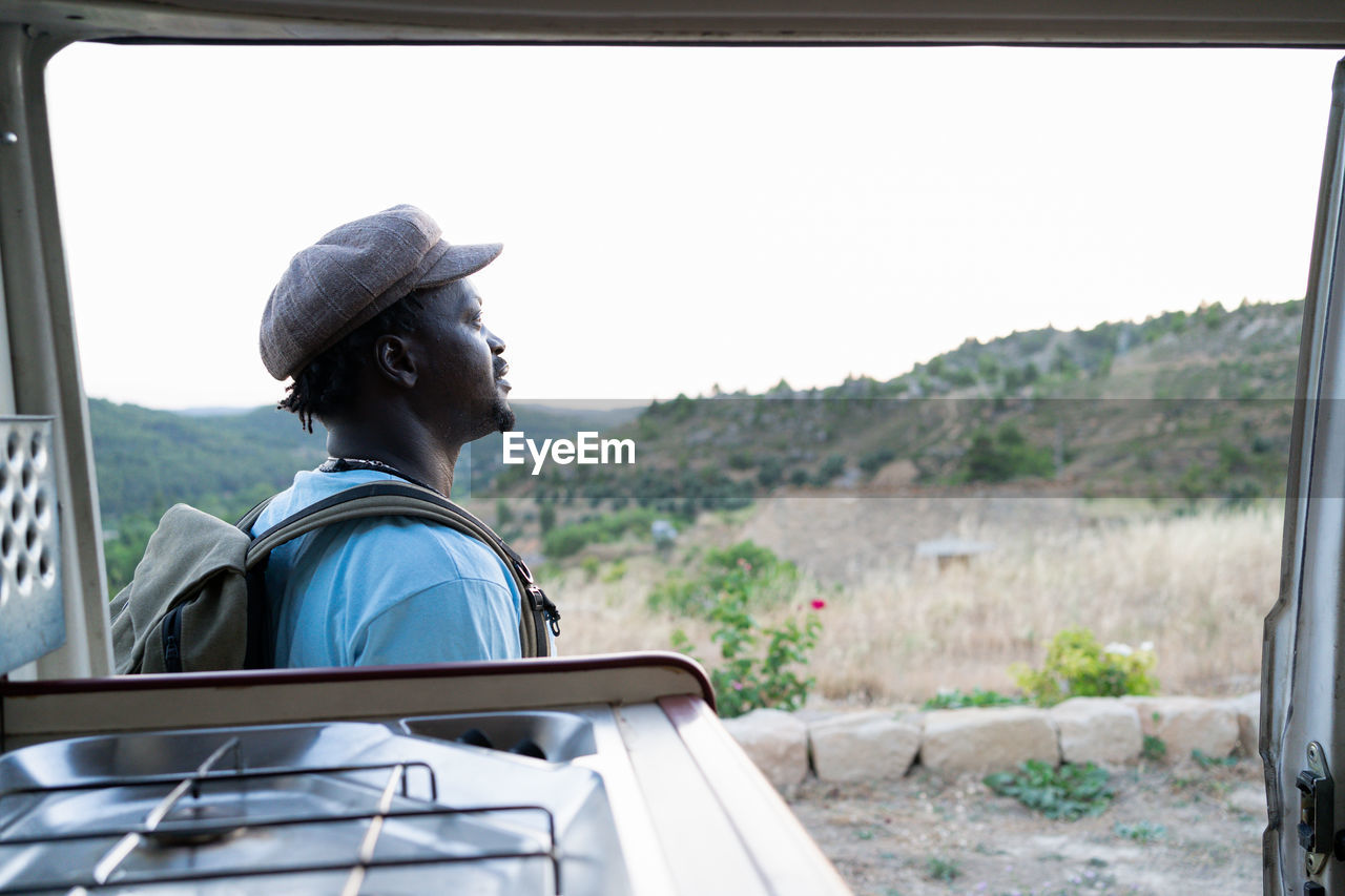 Black african american man with green backpack, travel concept