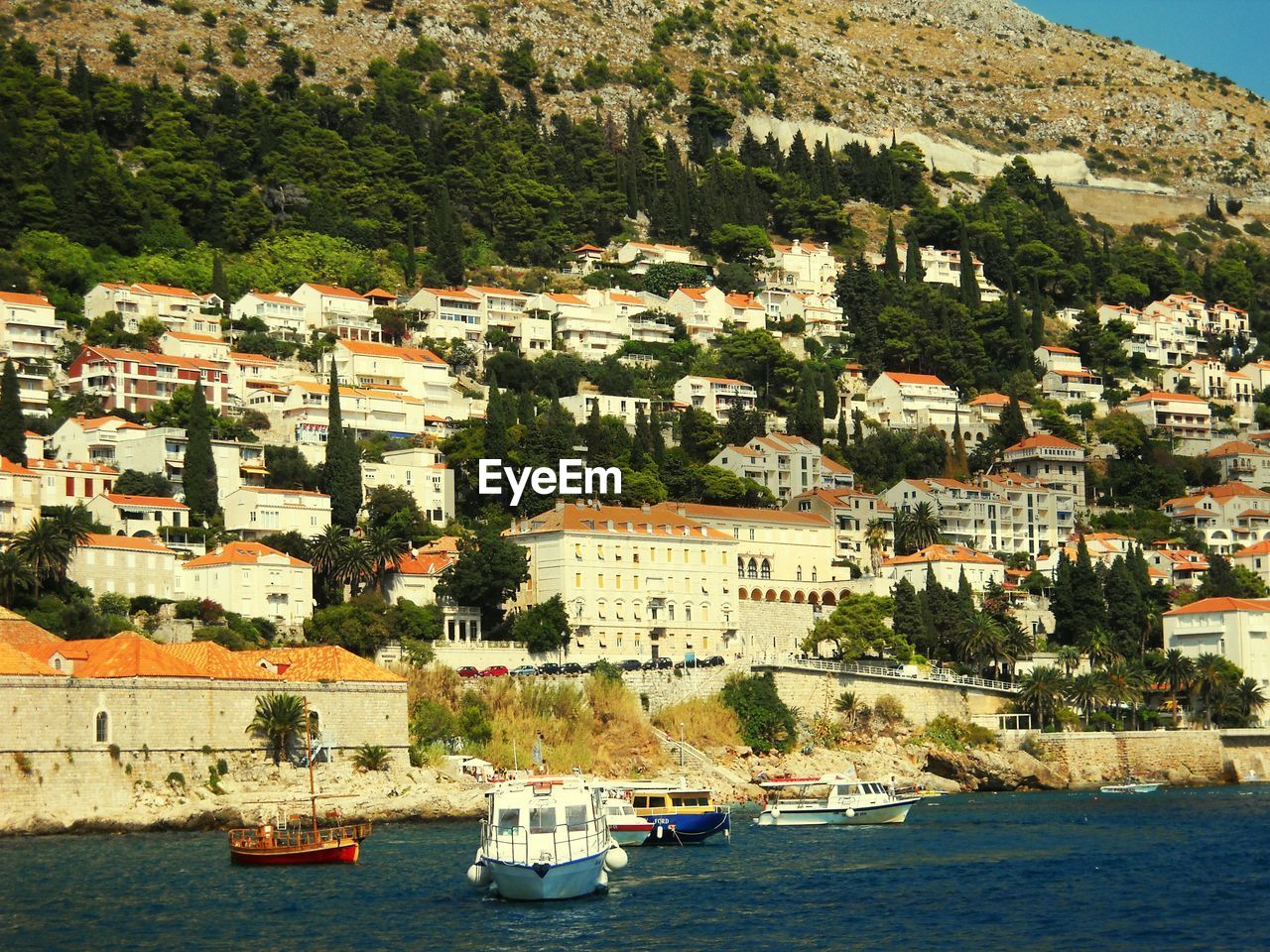 Boats in sea with city in background