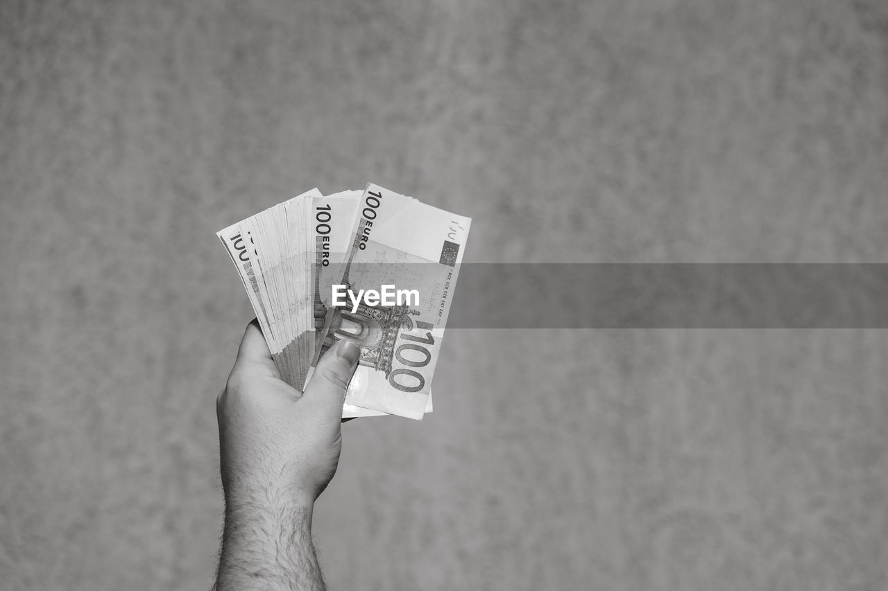 cropped hand of woman holding paper currency