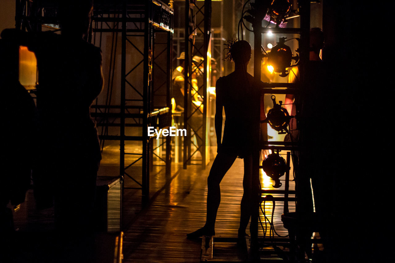 Silhouette of man standing in illuminated room