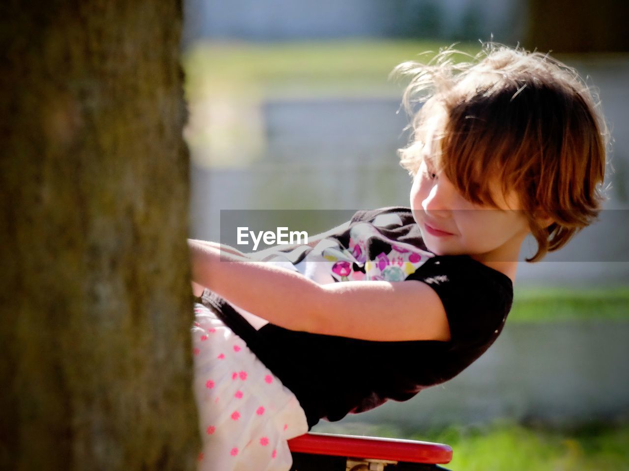 Side view of girl swinging on swing at park