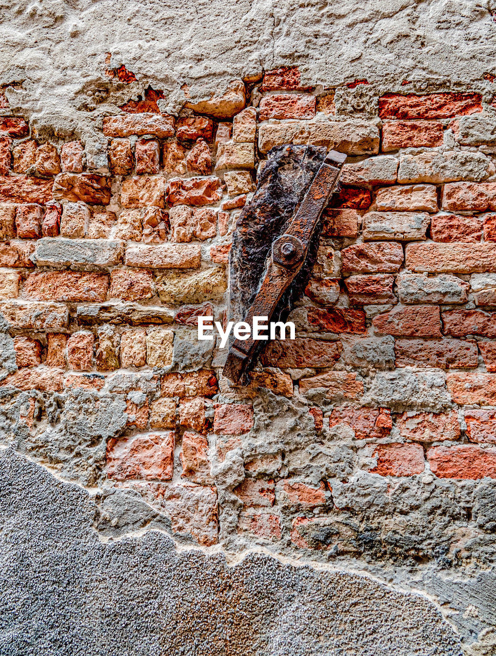 CLOSE-UP OF WEATHERED WALL WITH GRAFFITI