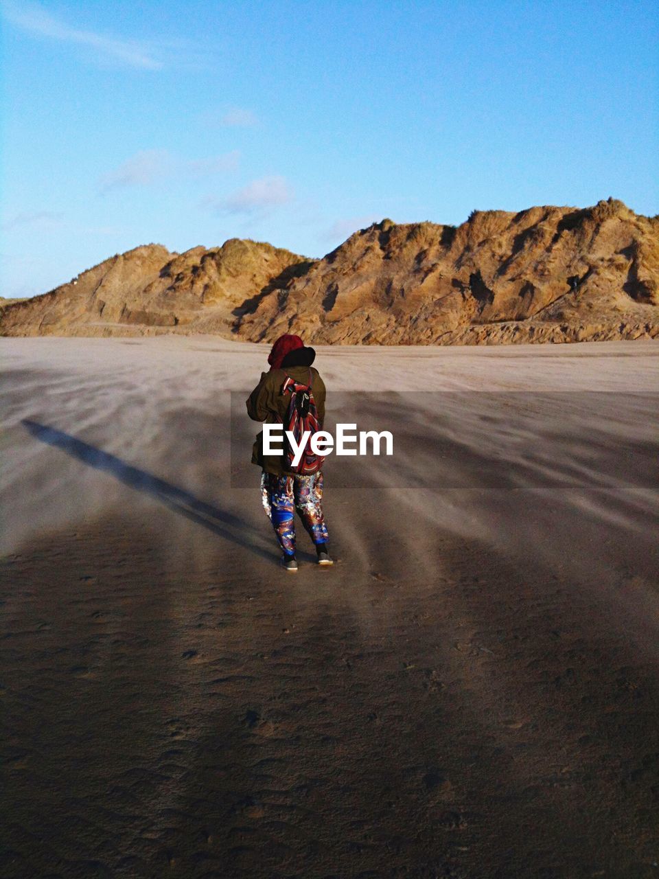 Rear view of woman standing at beach