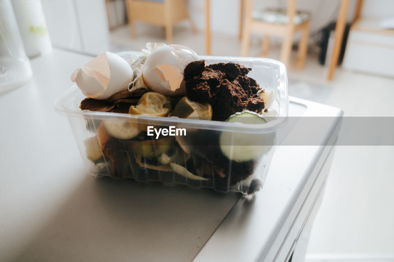 Organic waste in a small plastic box on table