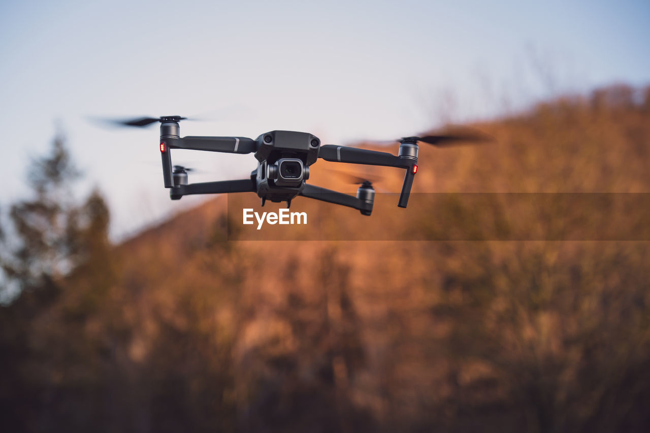 Low-angle view of a professional camera drone/quadrocopter at sunset