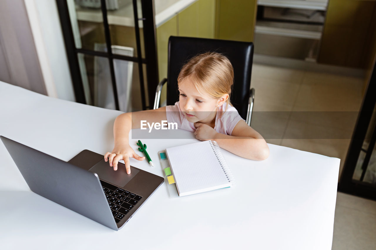 High angle view of girl using laptop at home