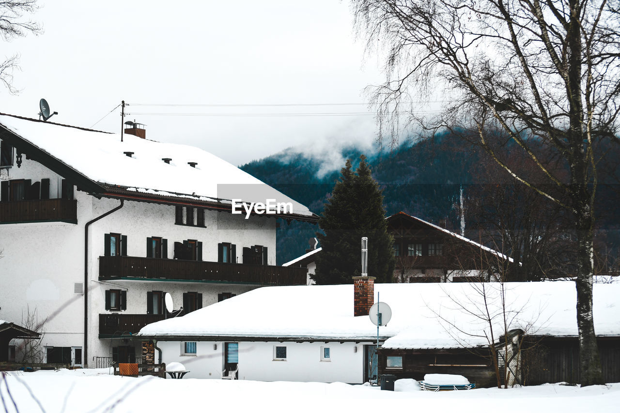 SNOW COVERED HOUSES AGAINST SKY