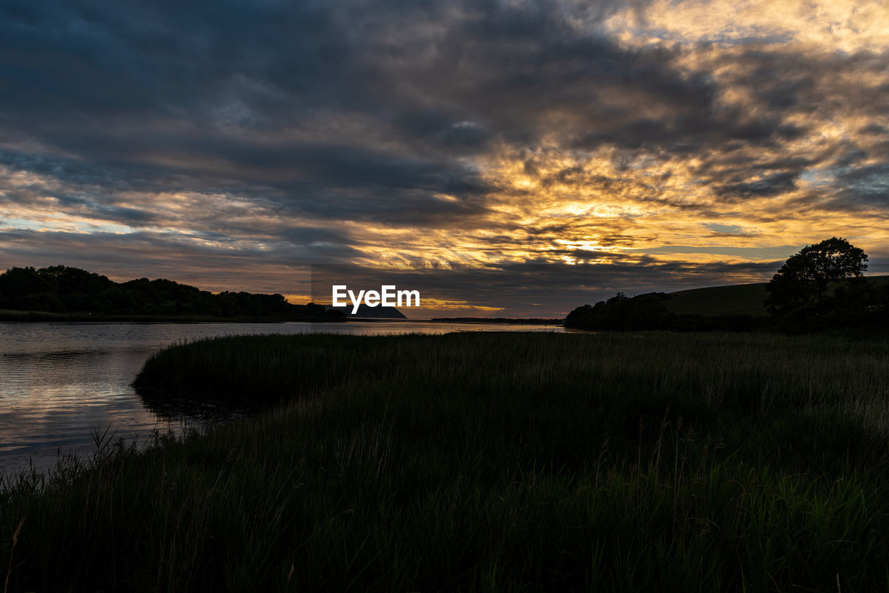 sky, cloud, nature, water, environment, sunset, landscape, beauty in nature, horizon, scenics - nature, dawn, land, plant, grass, tranquility, evening, no people, sea, reflection, dramatic sky, tranquil scene, coast, outdoors, beach, sunlight, travel destinations, shore, rural scene, sun, non-urban scene, travel, mountain, field, cloudscape, tree, twilight, idyllic