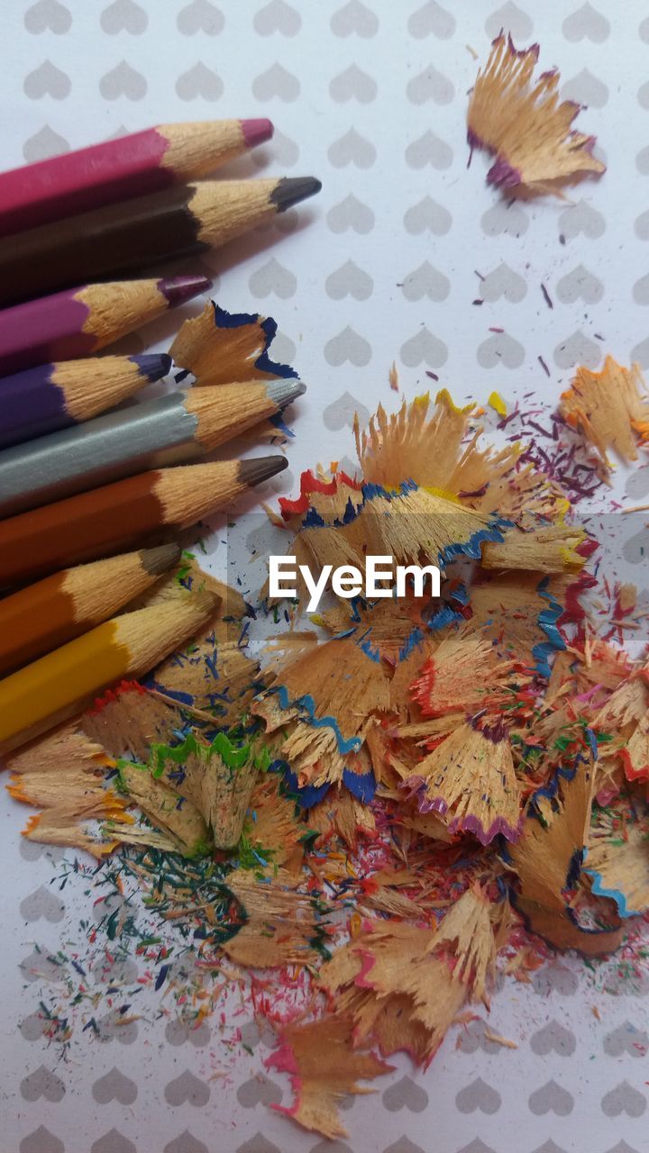 Close-up of colored pencils and shavings on table