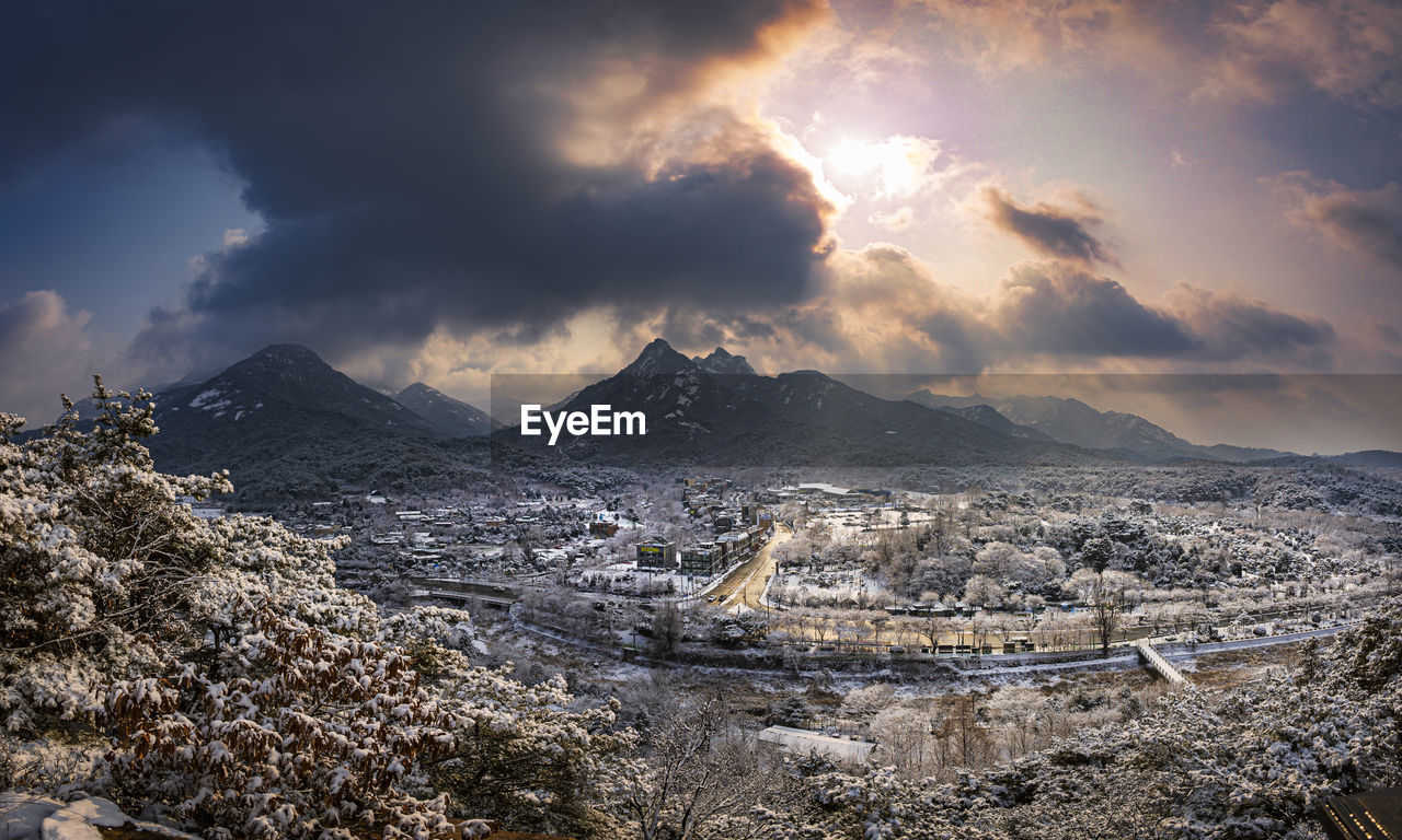 A snowy village and a thick layer of clouds.
the sunlight is cool.