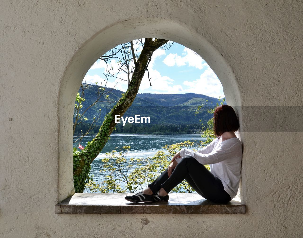 Woman sitting in window sill