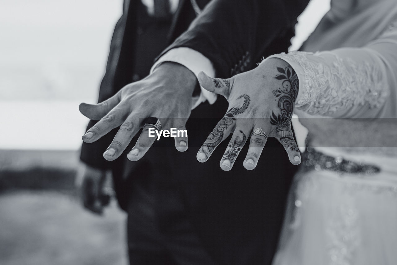 Newly married couple showing off their rings. bride's hand decorated with beautiful henna drawing