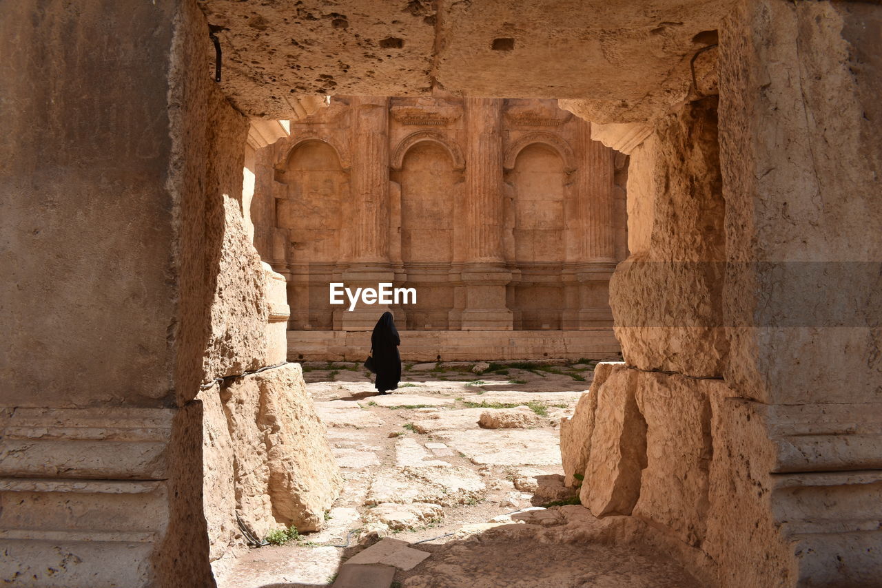 Rear view of woman wearing hijab walking in old building