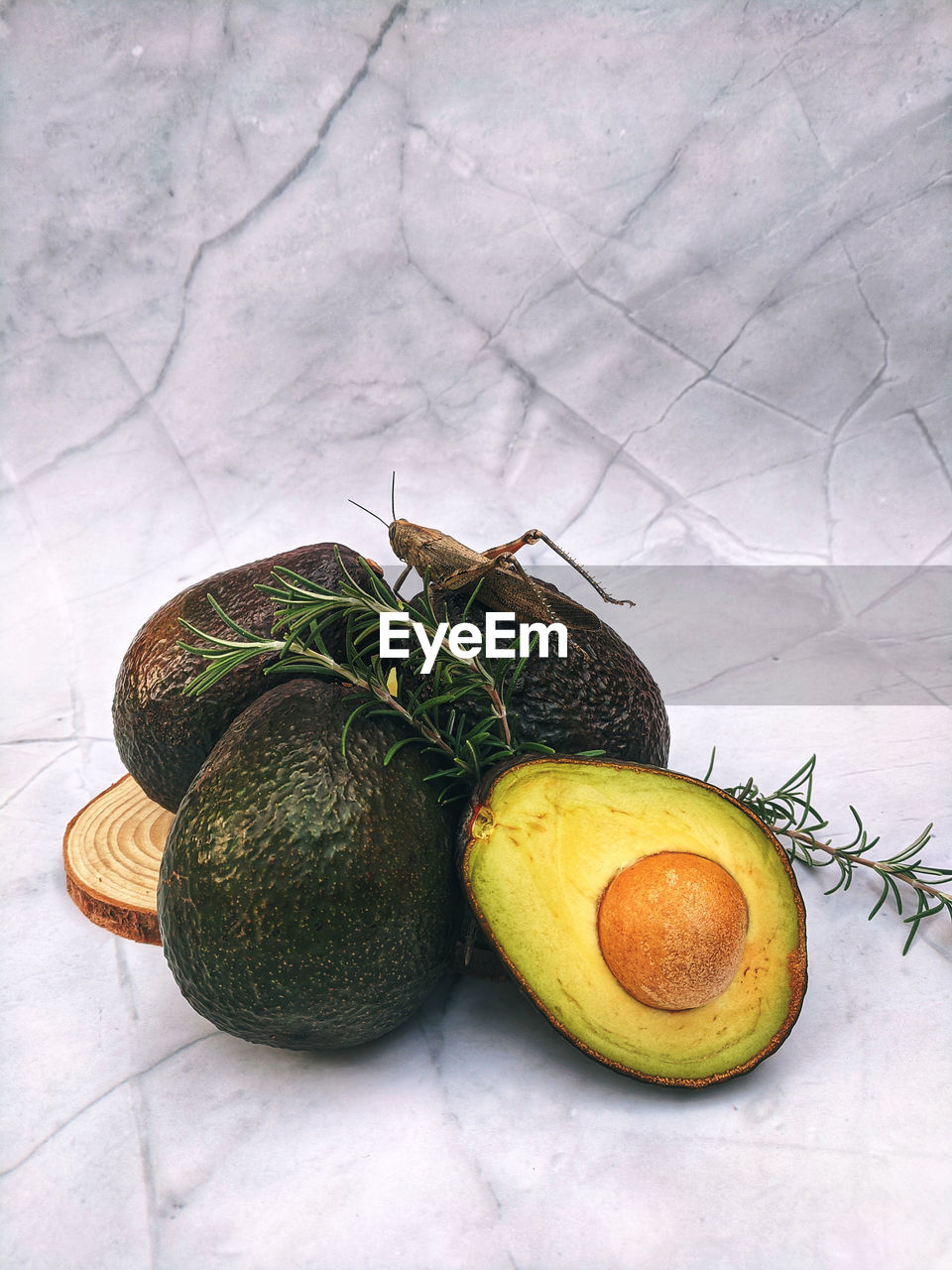 Fresh avocado with herbs and lemons lies on the table on white background. flat lay. top view.