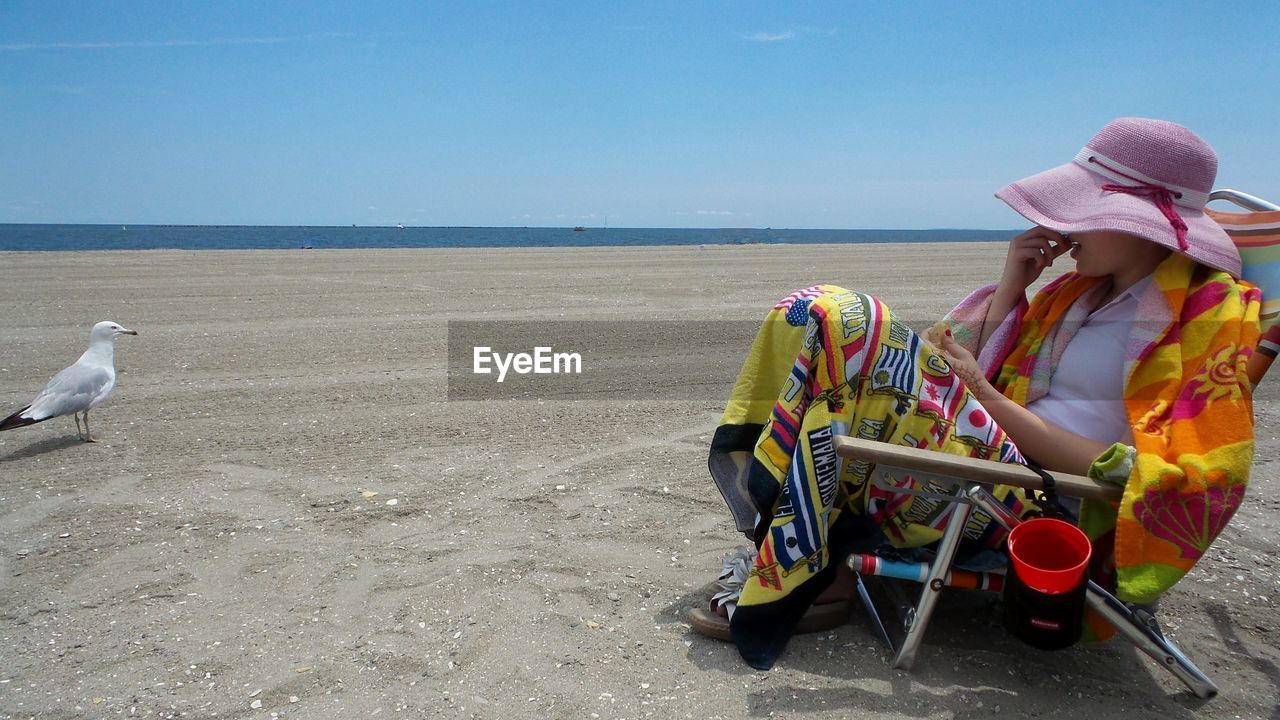 Woman on beach against clear sky