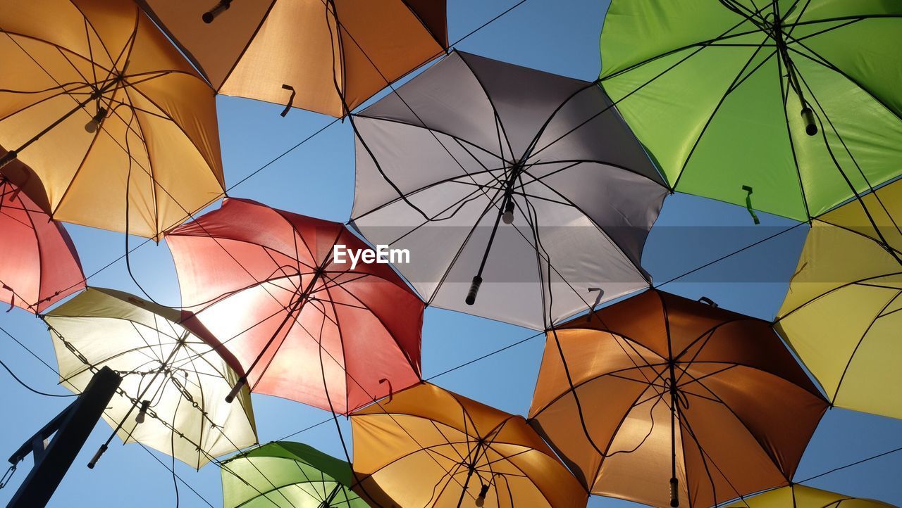 Low angle view of colorful umbrellas against clear sky