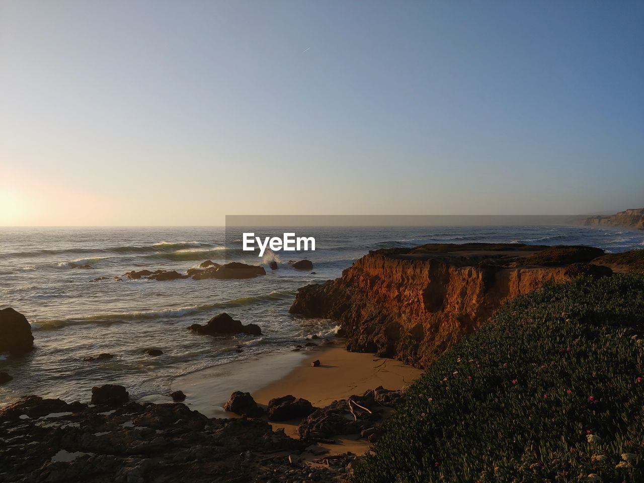 SCENIC VIEW OF BEACH AGAINST SKY AT SUNSET