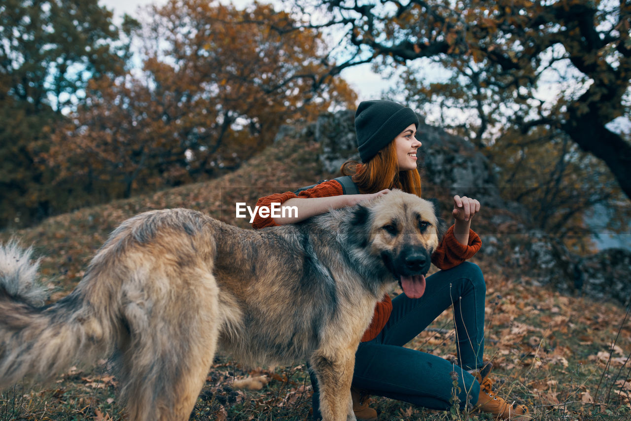 Full length of woman with dog on tree