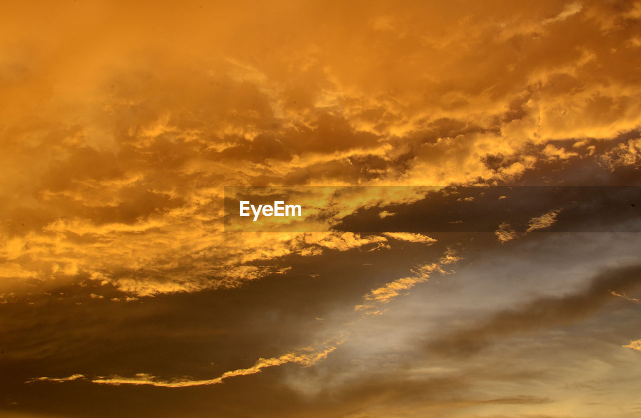 LOW ANGLE VIEW OF SUN STREAMING THROUGH CLOUDS