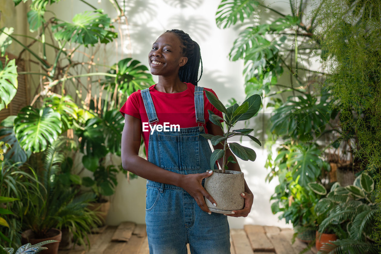 portrait of young woman standing amidst plants