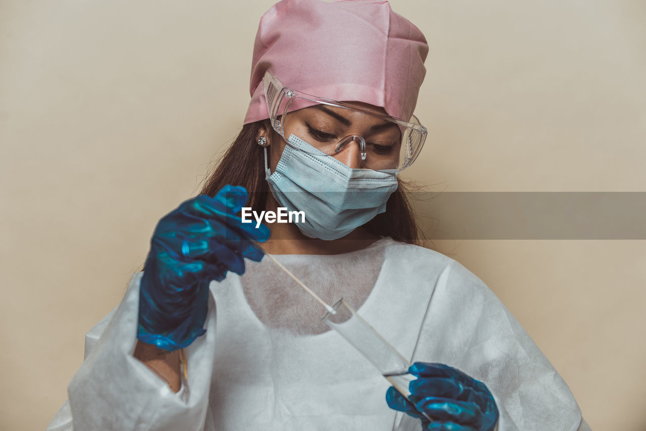 Doctor wearing mask against blue background